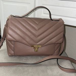 A newer purse in great condition, tan color with gold chain.